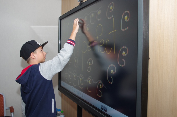 A child is writing on a blackboard | Lucky Kids